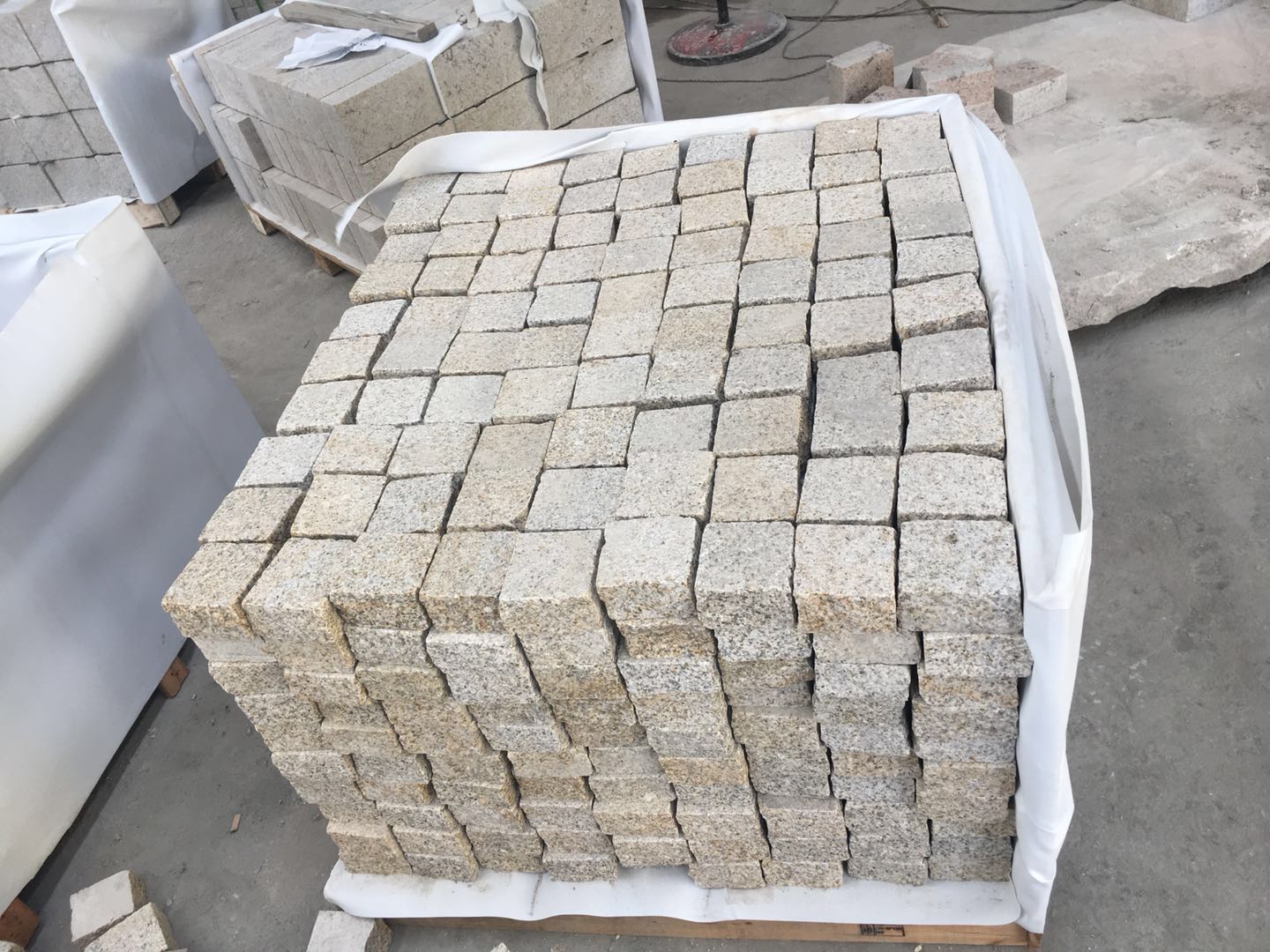 Natural Split Yellow Granite Cobble Stone Granite — Cobbles stacked and shrink-wrapped on a timber export pallet at Sun Young Stone