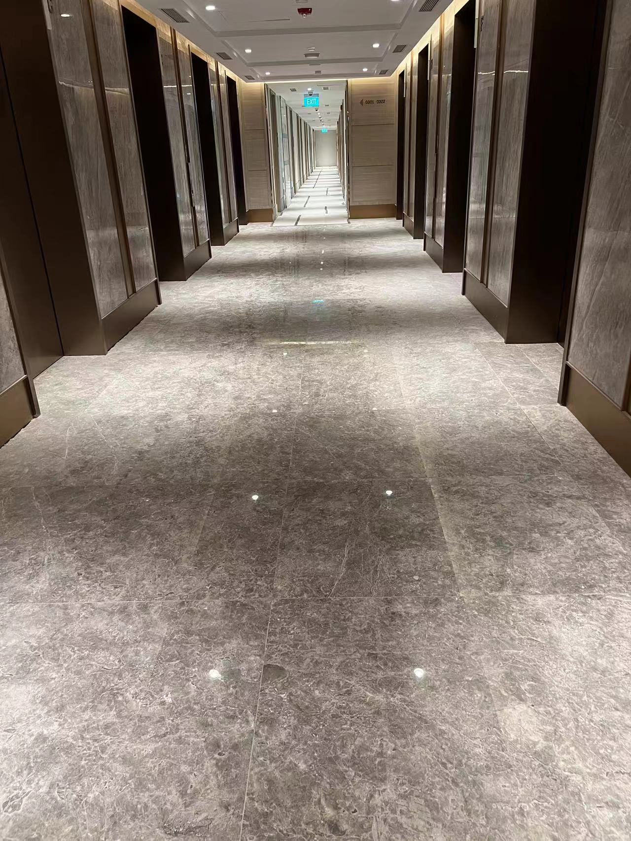 Long Icon Hotel Singapore guest-room corridor finished in polished Tundra Grey marble floor with marble-clad lift portals