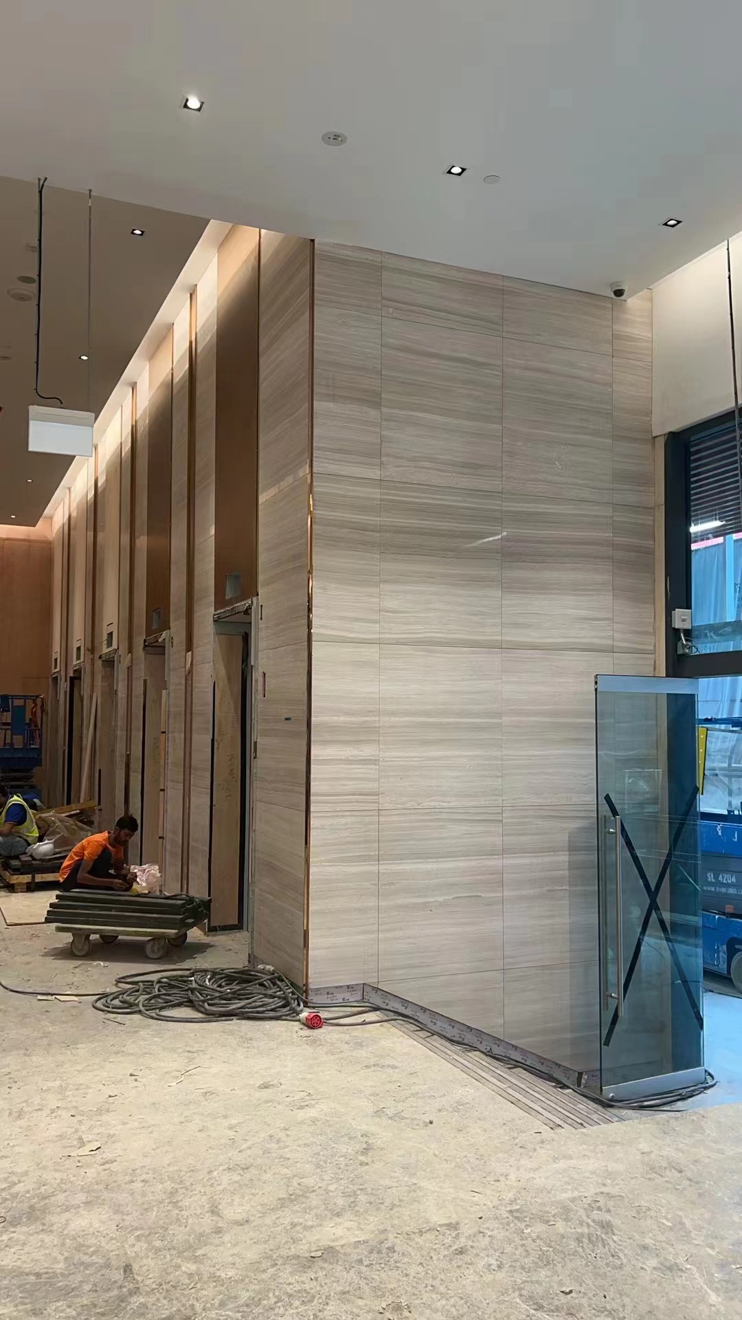 Double-height Icon Hotel Singapore lobby wall clad in Sandalwood Light white wood-vein marble during fit-out