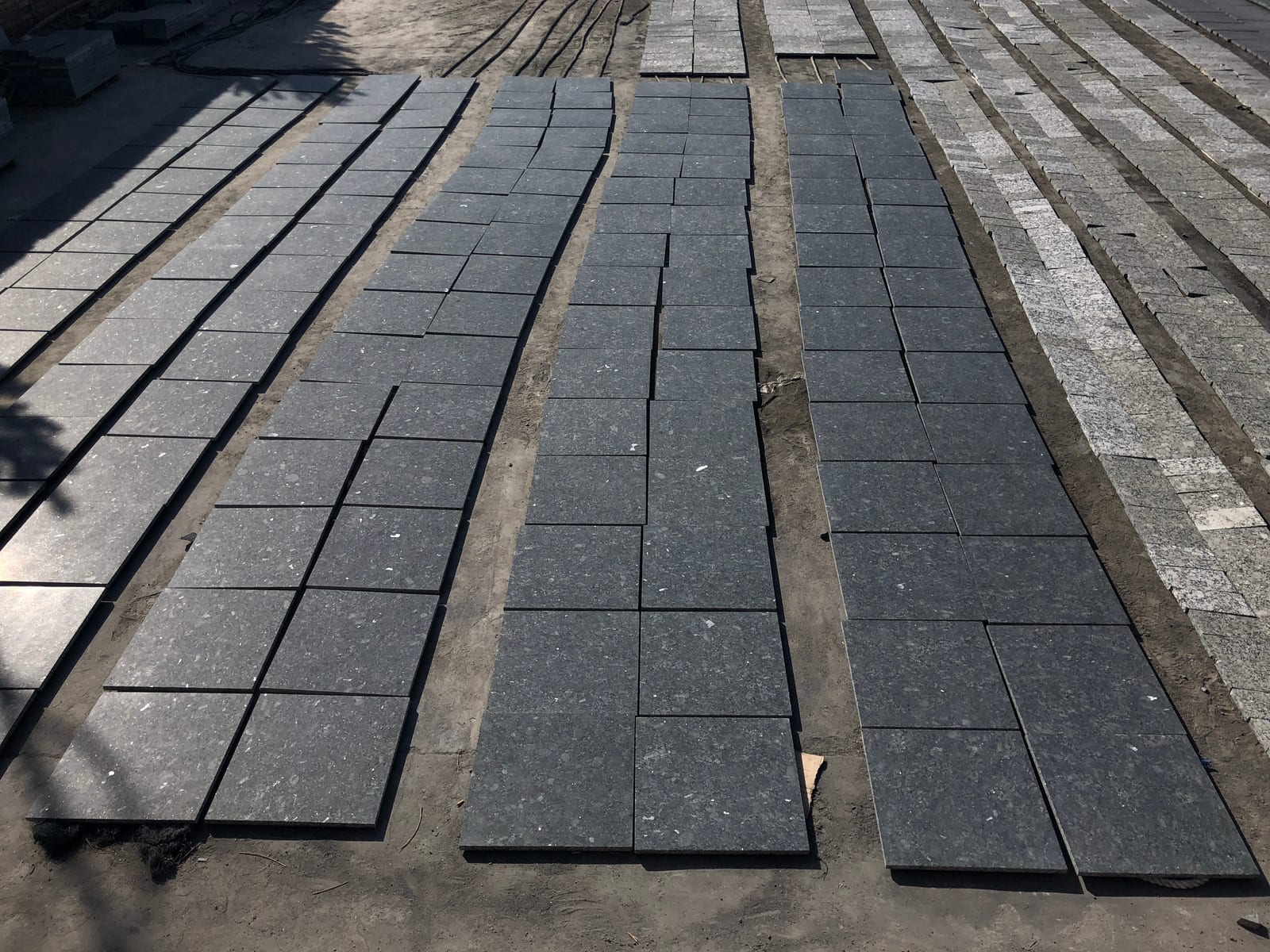 Rows of dark Breton Green granite tiles laid out to dry in the factory yard