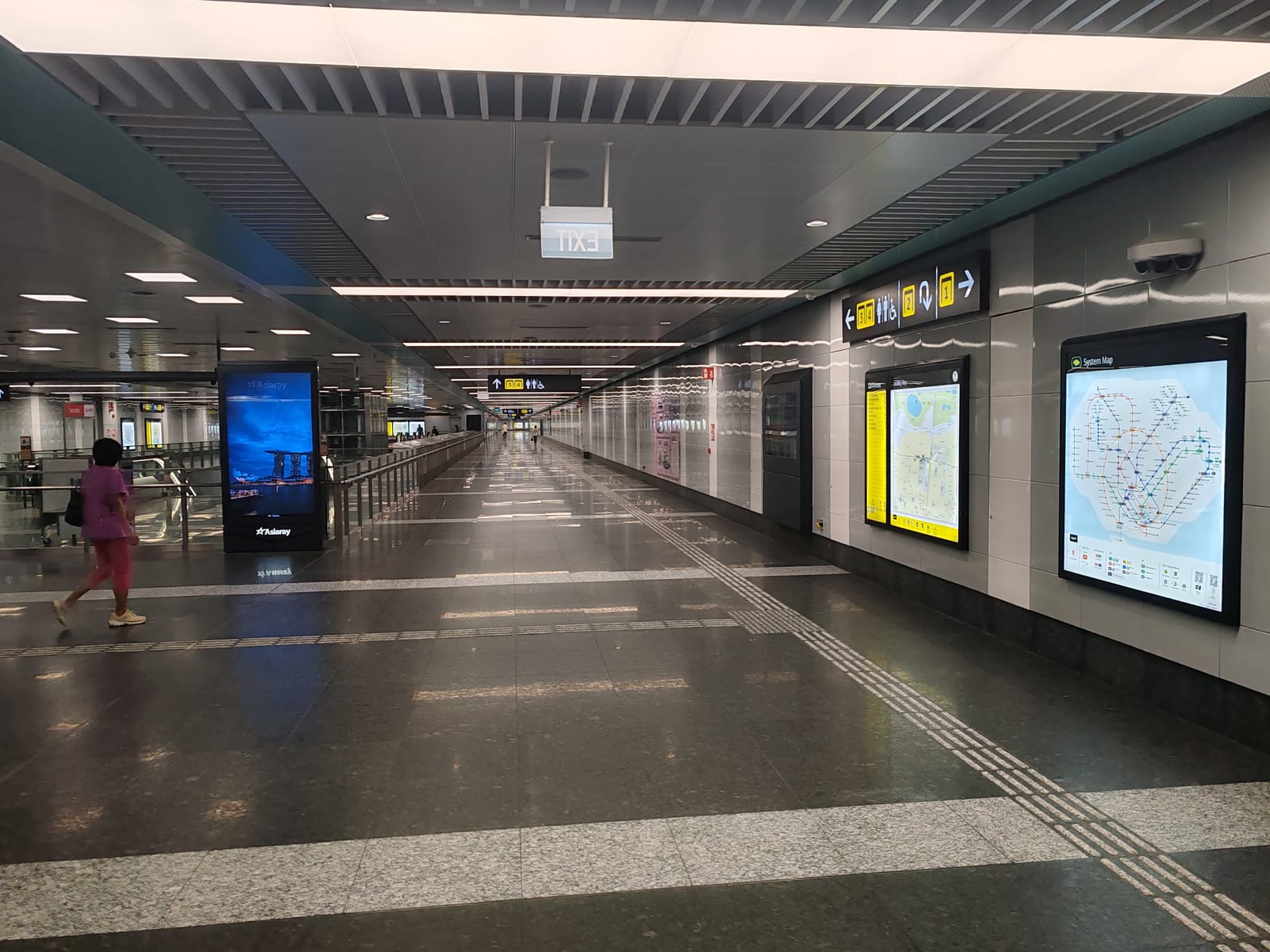 Polished granite concourse passageway at Siglap MRT Station with system maps along the wall