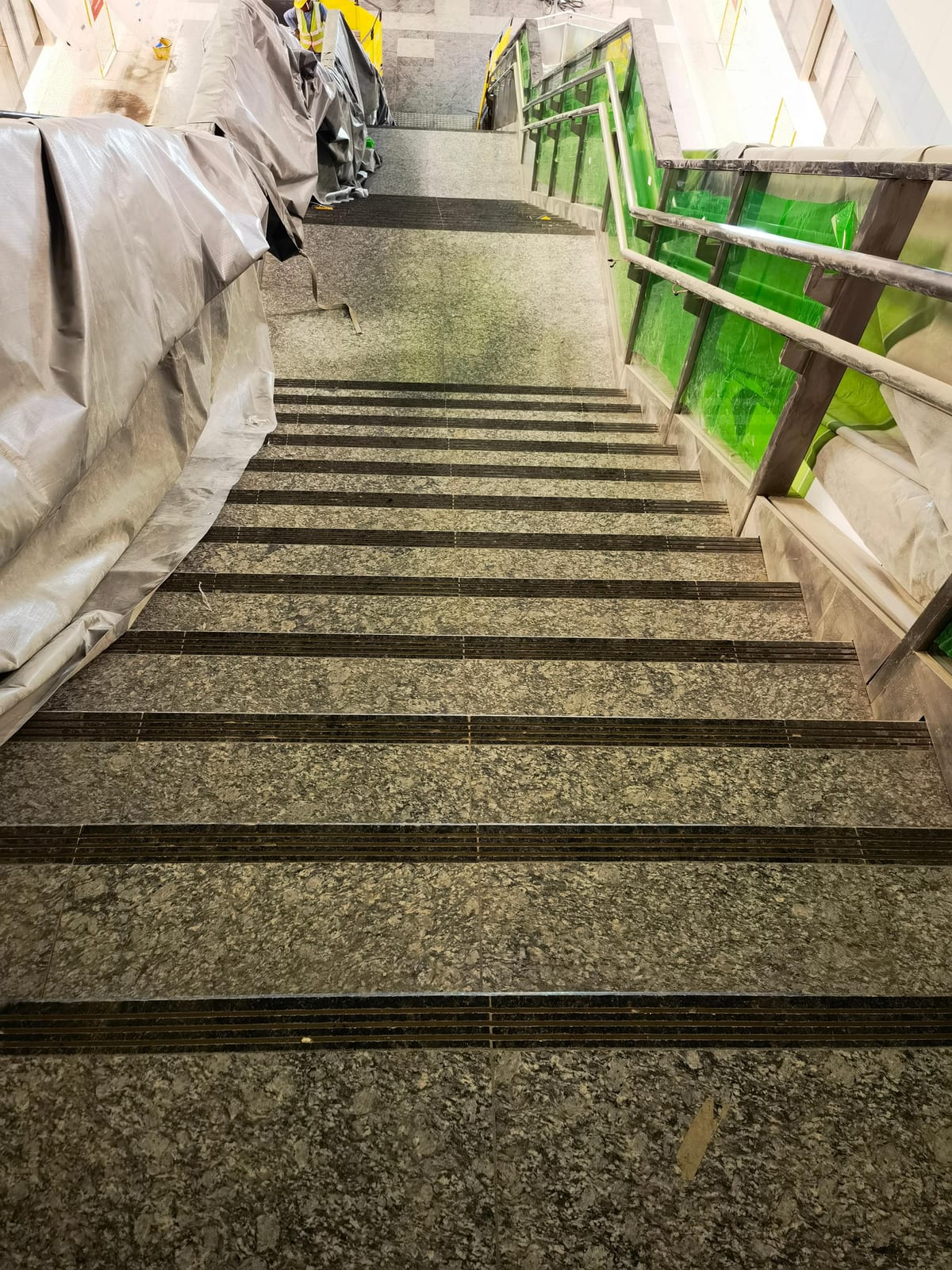 Granite staircase at Siglap MRT Station with recessed anti-slip nosing strips and a glass balustrade